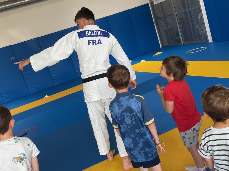 Youn Balcou, champion de France de parajudo issu de l’AC Penvenan, explique aux enfants les exercices du jour à un groupe d'enfants visiblement prêts à s'essayer au judo ! Youn Balcou, champion de France de parajudo issu de l’AC Penvenan, explique aux enfants les exercices du jour à un groupe d'enfants visiblement prêts à s'essayer au judo !