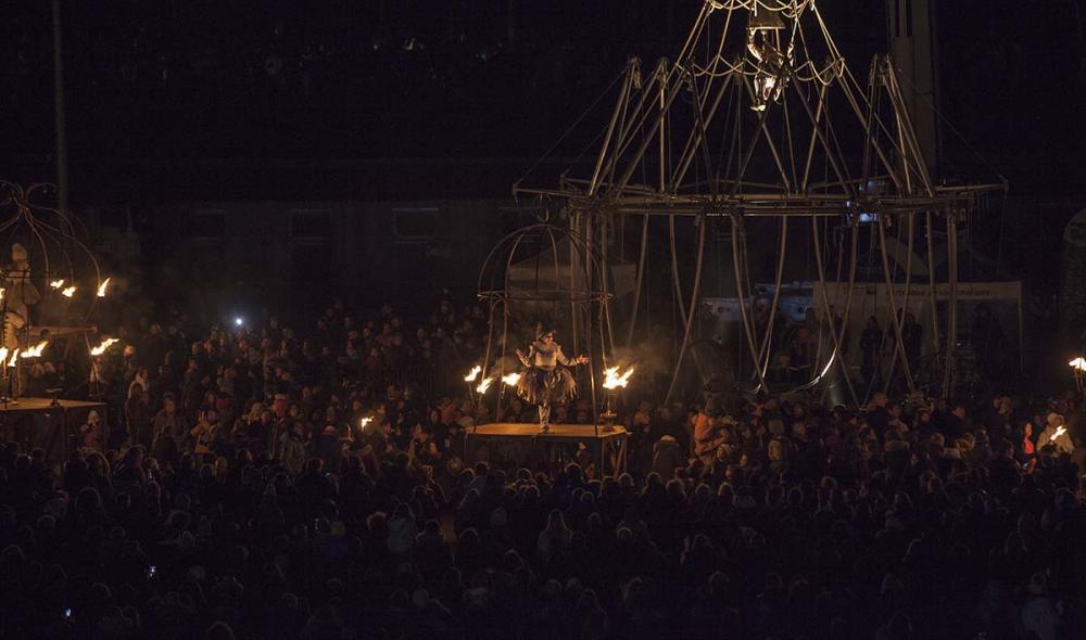 Personnage dans une cage illuminée au pied de la structure, agrandir l'image