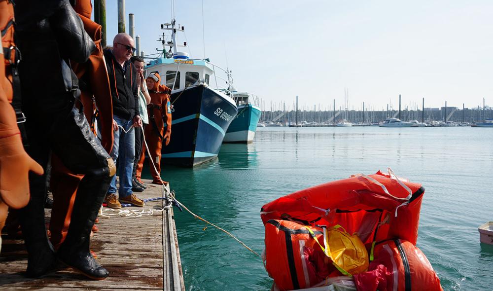 C’est le moment de déployer le canot de sauvetage. Celui-ci tient dans une valise et se gonfle grâce à une bonbonne de gaz. À l’intérieur, on trouve du matériel de pêche, des feux de détresse, un miroir permettant de refléter les rayons du soleil : le minimum pour survivre en mer et signaler la présence des naufragés aux secours.
